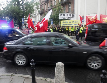 在华沙喜来登酒店附近街道妄图遮挡法轮功条幅的伎俩失败了,法轮功横幅清晰可见。(黄诃欧/大纪元)